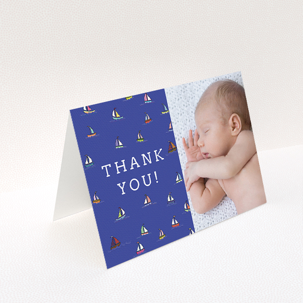 A baby thank you card template titled "Cowes Week". It is an A5 card in a landscape orientation. It is a photographic baby thank you card with room for 1 photo. "Cowes Week" is available as a folded card, with mainly blue colouring.