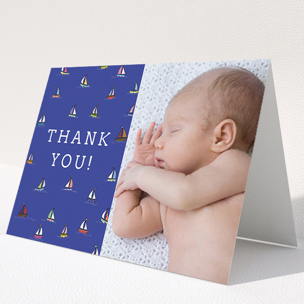A baby thank you card template titled "Cowes Week". It is an A5 card in a landscape orientation. It is a photographic baby thank you card with room for 1 photo. "Cowes Week" is available as a folded card, with mainly blue colouring.