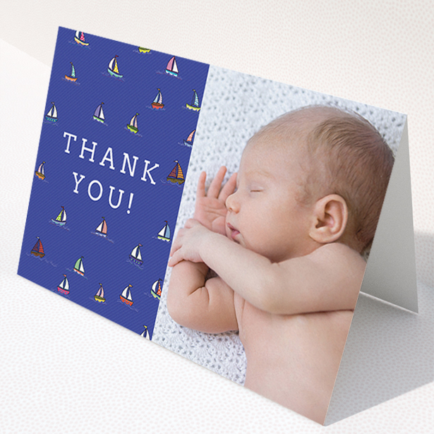 A baby thank you card template titled "Cowes Week". It is an A5 card in a landscape orientation. It is a photographic baby thank you card with room for 1 photo. "Cowes Week" is available as a folded card, with mainly blue colouring.