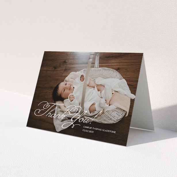 A baby thank you card called "Flourished Thank You". It is an A5 card in a landscape orientation. It is a photographic baby thank you card with room for 1 photo. "Flourished Thank You" is available as a folded card, with mainly white colouring.