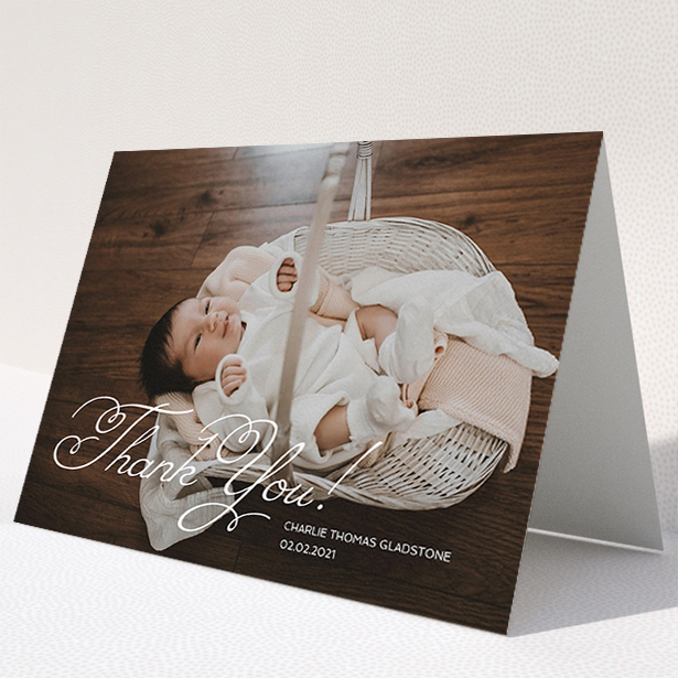 A baby thank you card called "Flourished Thank You". It is an A5 card in a landscape orientation. It is a photographic baby thank you card with room for 1 photo. "Flourished Thank You" is available as a folded card, with mainly white colouring.