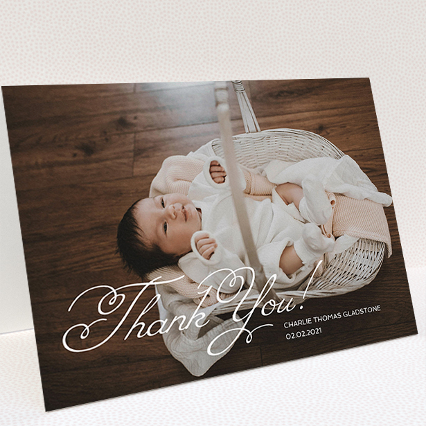 A baby thank you card called "Flourished Thank You". It is an A5 card in a landscape orientation. It is a photographic baby thank you card with room for 1 photo. "Flourished Thank You" is available as a folded card, with mainly white colouring.