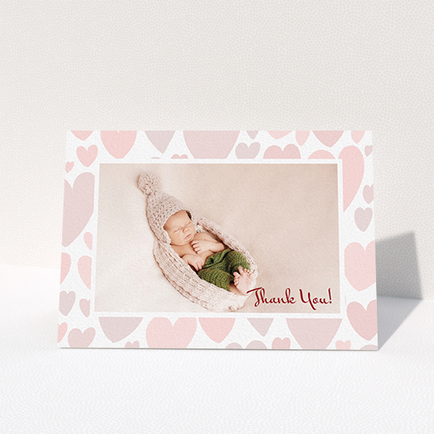 A christening thank you card called "Pastel Hearts". It is an A6 card in a landscape orientation. It is a photographic christening thank you card with room for 1 photo. "Pastel Hearts" is available as a folded card, with tones of pink and white.