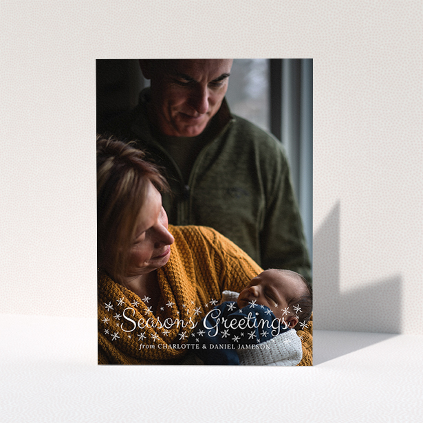 A family christmas card template titled "Sparkling Snow". It is an A5 card in a portrait orientation. It is a photographic family christmas card with room for 1 photo. "Sparkling Snow" is available as a folded card, with mainly white colouring.