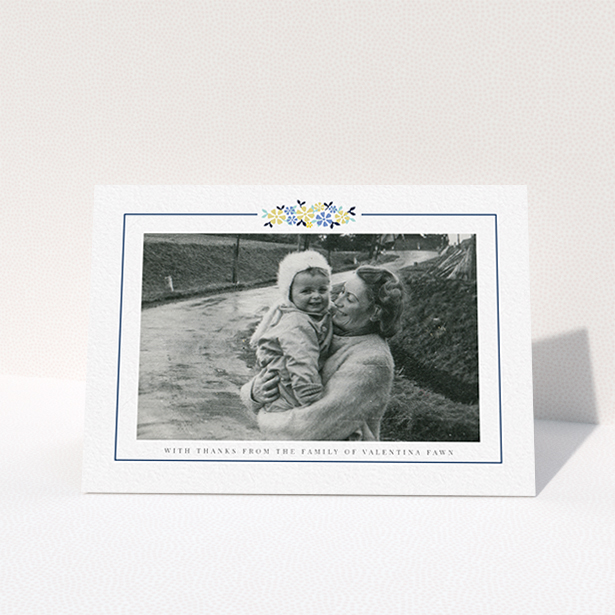 A funeral thank you card called "Remembered in flowers". It is an A6 card in a landscape orientation. It is a photographic funeral thank you card with room for 1 photo. "Remembered in flowers" is available as a folded card, with tones of white and blue.