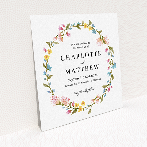 A personalised wedding invite template titled "Spring Wreath". It is a square (148mm x 148mm) invite in a square orientation. "Spring Wreath" is available as a flat invite, with mainly pink colouring.