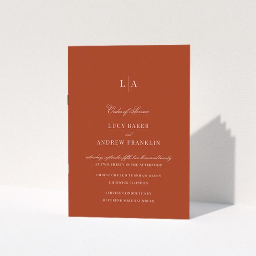 Wedding Order Of Service Design - "Dark Ochre Monogrammed" A wedding order of service named "Dark Ochre Monogrammed". It is an A5 booklet in a portrait orientation. "Dark Ochre Monogrammed" is available as a folded booklet booklet, with mainly dark orange colouring.