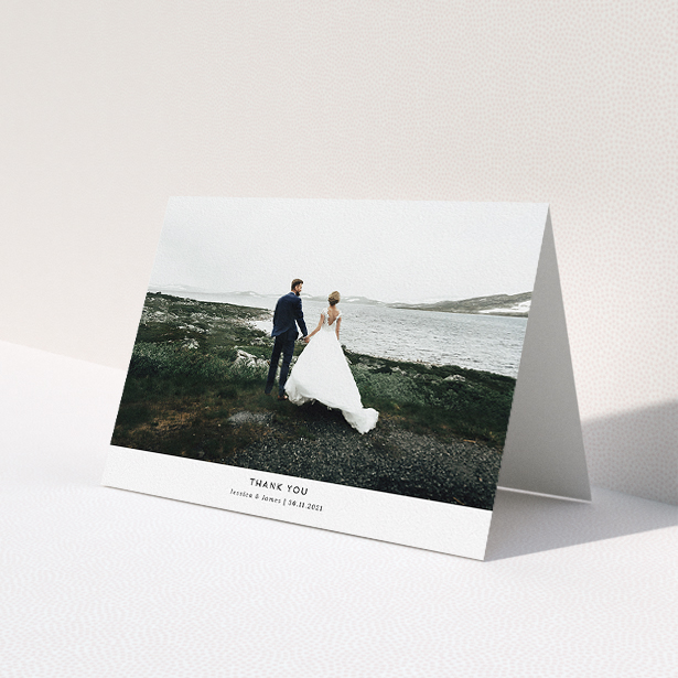 A wedding thank you card named "Sans Serif". It is an A5 card in a landscape orientation. It is a photographic wedding thank you card with room for 1 photo. "Sans Serif" is available as a folded card, with mainly white colouring.