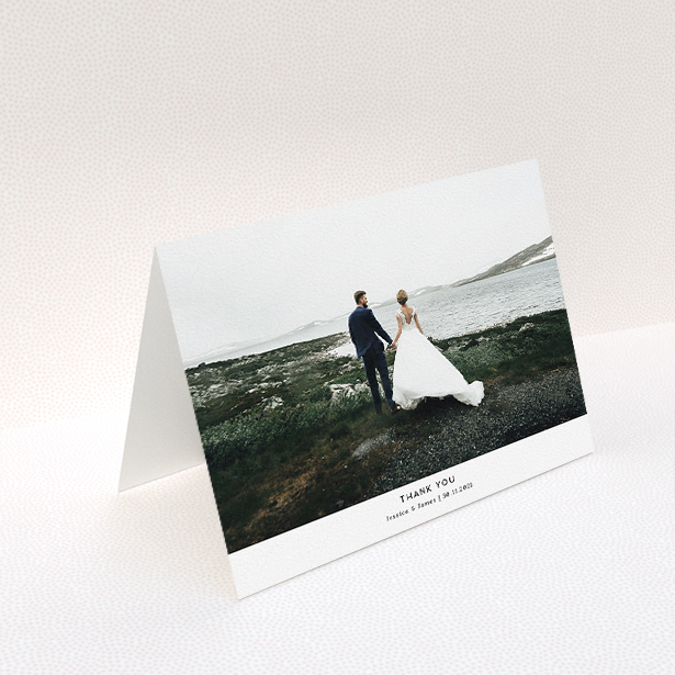 A wedding thank you card named "Sans Serif". It is an A5 card in a landscape orientation. It is a photographic wedding thank you card with room for 1 photo. "Sans Serif" is available as a folded card, with mainly white colouring.