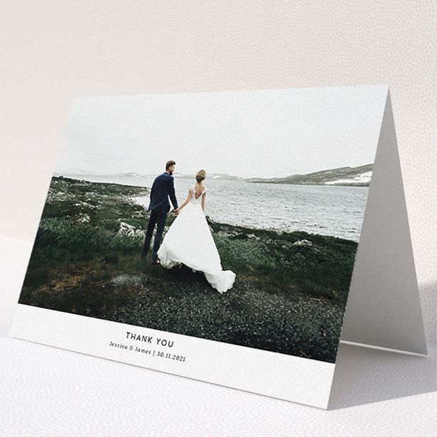 A wedding thank you card named "Sans Serif". It is an A5 card in a landscape orientation. It is a photographic wedding thank you card with room for 1 photo. "Sans Serif" is available as a folded card, with mainly white colouring.