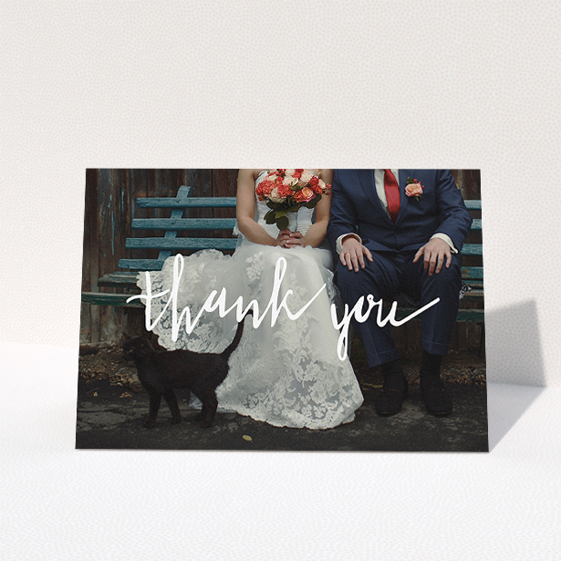 A wedding thank you card template titled "Wonky thank you". It is an A5 card in a landscape orientation. It is a photographic wedding thank you card with room for 1 photo. "Wonky thank you" is available as a folded card, with mainly white colouring.